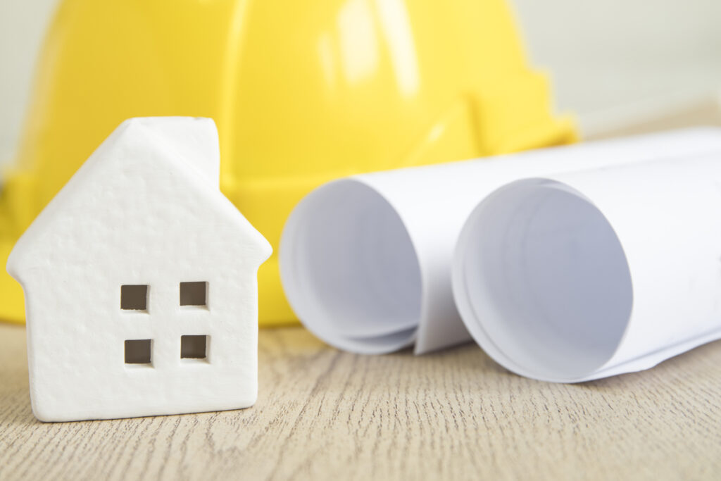 toy house near blueprints helmet